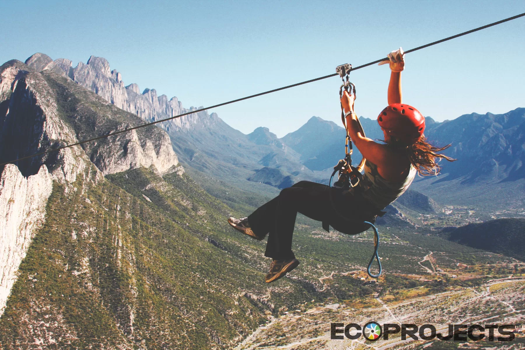 Ecoproparks | Tirolesa – Zip Line México Ecoproparks. Persona usando tirolesa con vista a las montañas.